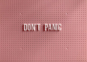 panic disorder and panic attacks – illustrated by a pink peg board sign with white letters that reads 'DON'T PANIC'