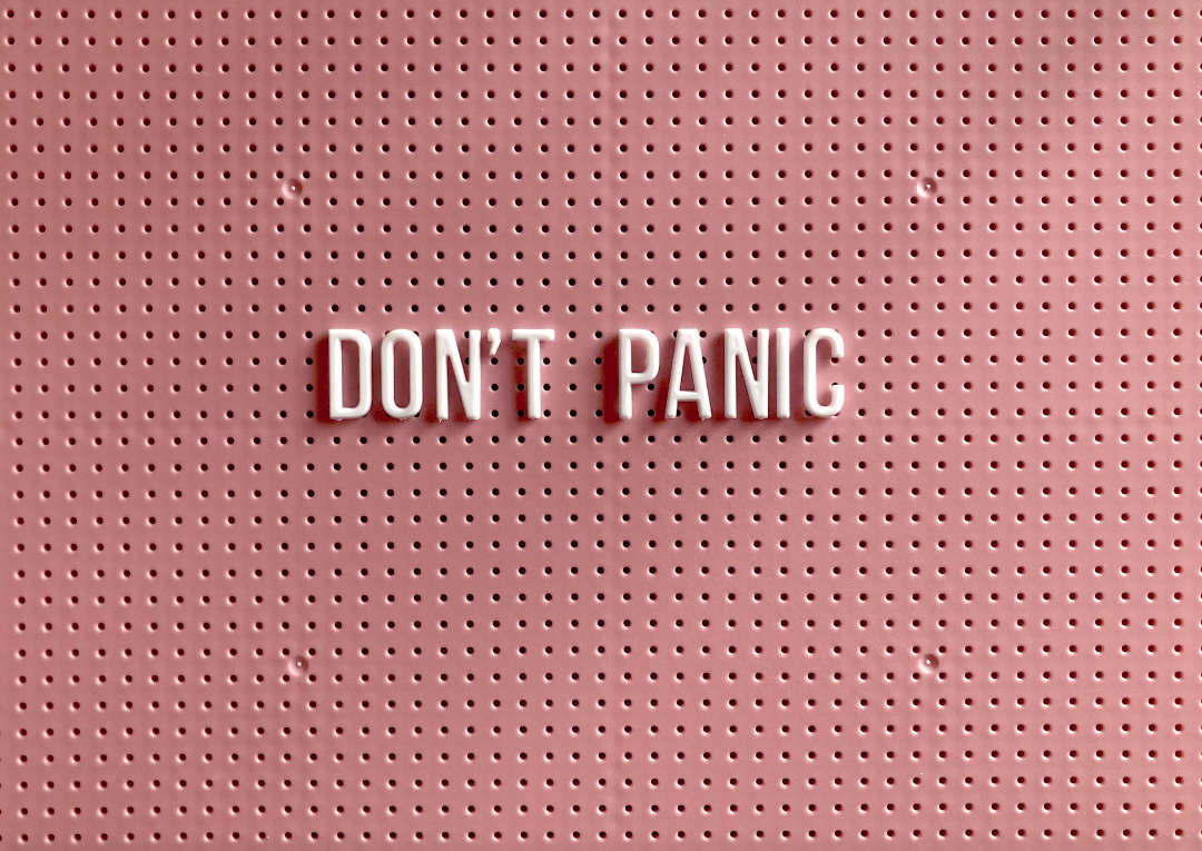 panic disorder and panic attacks – illustrated by a pink peg board sign with white letters that reads 'DON'T PANIC'