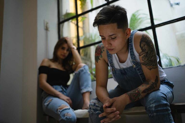 Lesbian couple looking upset after having an argument at home. LGBTQ Couples Therapy in Melbourne – Safe Place Therapy